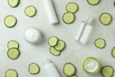 Beyaz desenli arka planda kozmetik ve salatalık dilimleri