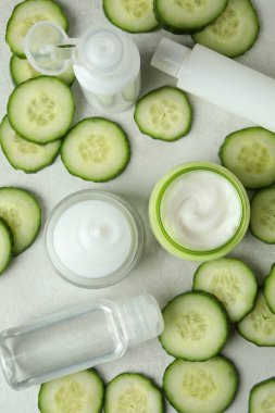 Beyaz desenli arka planda kozmetik ve salatalık dilimleri