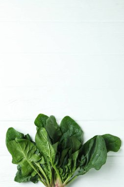 Beyaz ahşap arka planda taze çiğ ıspanak.