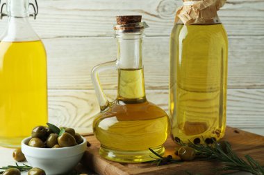 Beyaz ahşap arka plana karşı zeytinyağı şişeleri