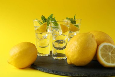Limonlu shot ve sarı arka planda nane şekeri.