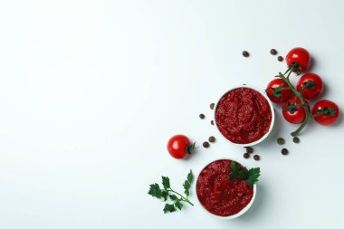 Beyaz arka planda domates, biber ve maydanozlu kaseler.