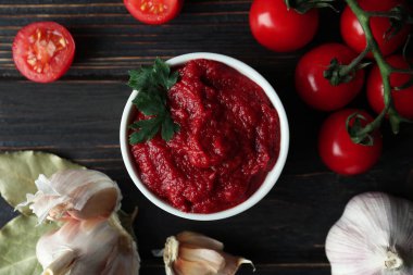 Tahta masada domates, domates ve sarımsaklı kase.