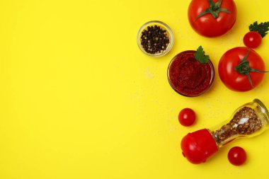 Bir kase domates ezmesi ve sarı arkaplanda malzemeler, metin için boşluk