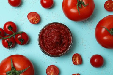 Mavi zemin üzerinde domates, domates ve tuz olan bir kase.