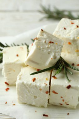 Baharatlı Feta peyniri ve beyaz ahşap arka planda biberiye.