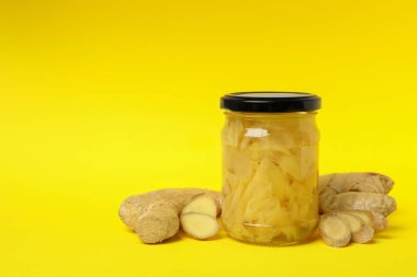 Sarı arka planda zencefil ve zencefil turşulu kavanoz