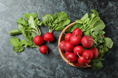 Siyah dumanlı masada taze turplu kase.