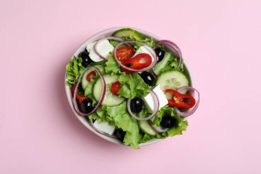 Pembe arka planda bir kase Yunan salatası
