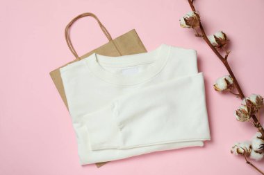 Beyaz kazak, çanta ve pembe arka planda pamuk.