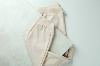 Beyaz desenli arka planda katlanmış eşofman üstü, üst görünüm