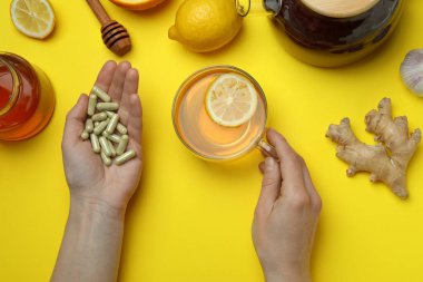Sarı arka planda kadın eli ve alternatif ilaçlar.