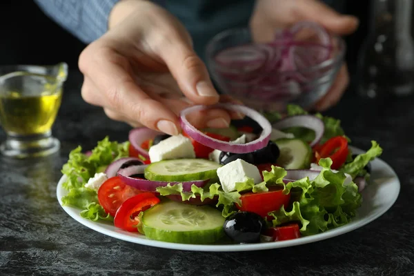 Kadın Siyah Dumanlı Masada Yunan Salatasına Soğan Koydu — Stok fotoğraf