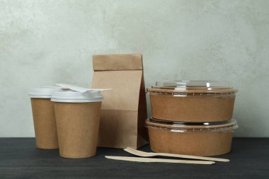 Koyu ahşap masadaki paket yiyecek konteynırları.