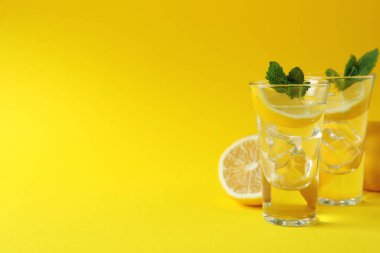 Limonlu shot ve sarı arkaplanda nane şekeri.