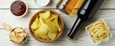 Farklı aperatifler, bira ve soslar beyaz ahşap arka planda