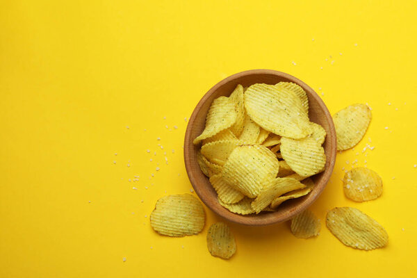 Чаша с картофельными чипсами на желтом фоне