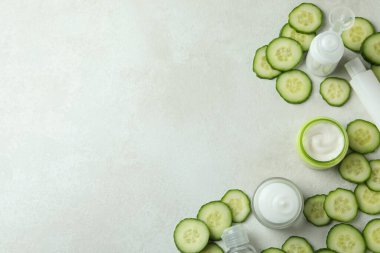 Beyaz desenli arka planda kozmetik ve salatalık dilimleri