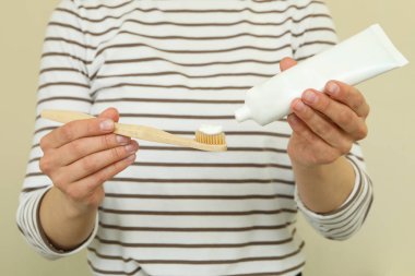 Kadın diş pudrası ve diş macunu tutuyor.