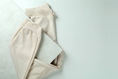 Beyaz desenli arkaplanda katlanmış eşofman altı, metin için boşluk