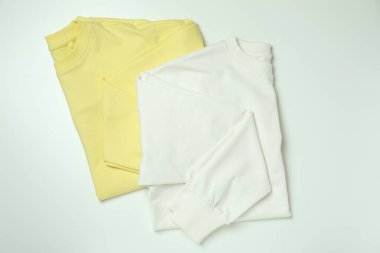 Beyaz arkaplanda beyaz ve sarı kazaklar