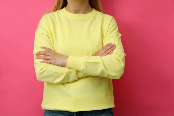 若いです女性で黄色のトレーナーに対してピンクの背景 — ストック写真