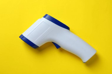 Sarı arka planda termometre tabancası, kapat.