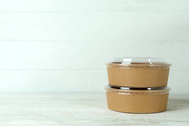 Blank paper bowls on white wooden table