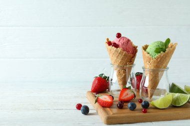 Dondurmalı koniler ve beyaz ahşap arka planda malzemeler.