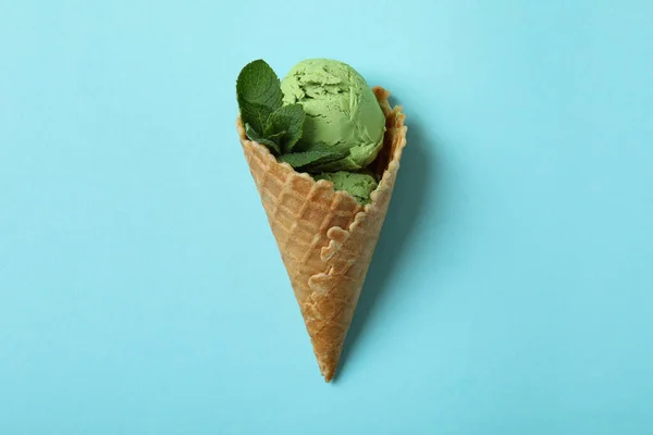 Cone of mint ice cream on blue background