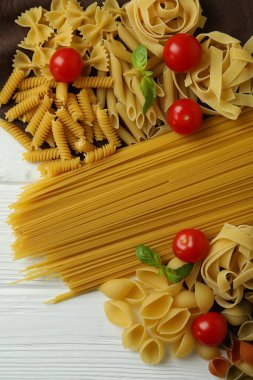 Beyaz ahşap arka planda mutfak havlusunda pişmemiş makarna.