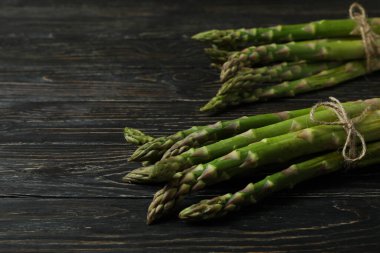 Ahşap arka planda bir sürü yeşil kuşkonmaz.