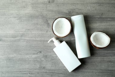 Gri desenli arka planda duş jelleri ve hindistan cevizi