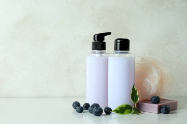 Beyaz desenli arka plana karşı doğal banyo kozmetiği ve yabanmersini.