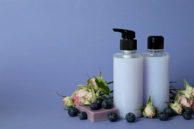 Doğal duş jeli ve mor arka plandaki malzemeler