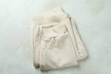 Beyaz desenli arka planda katlanmış eşofman üstü, üst görünüm