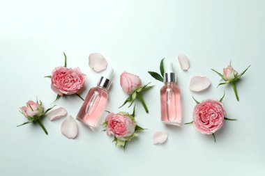 Beyaz arka planda gül yağı ve güllerle cilt bakımı kavramı