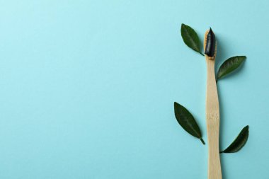 Diş macunlu ve mavi arka planda yapraklı çevre dostu diş fırçası