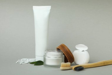 Gri arka planda ağız sağlığı aksesuarları, boş tüp