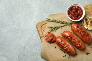 Gri desenli arka planda ızgara sosisli kesme tahtası