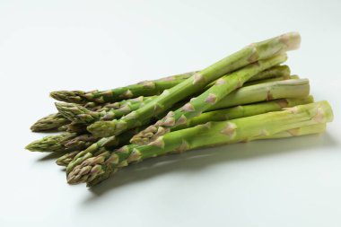 Beyaz arka planda taze yeşil kuşkonmaz, yakın plan.