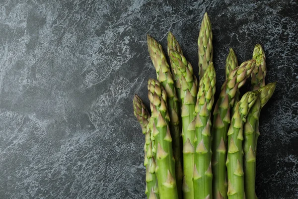 Siyah dumanlı arka planda taze yeşil kuşkonmaz
