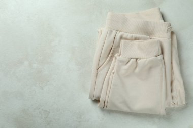 Beyaz desenli arkaplanda katlanmış eşofman altı, metin için boşluk