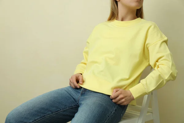 Mujer Joven Sudadera Amarilla Sentada Sobre Fondo Beige —  Fotos de Stock