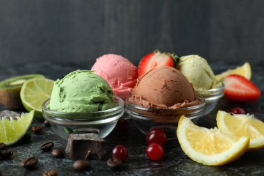 Meyveli dondurma ve siyah dumanlı masada malzemeler.