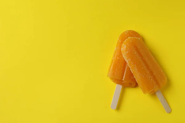 Mango ice cream sticks on yellow background