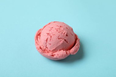 Mavi arka planda çilekli dondurma topu.