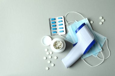 Açık gri arkaplanda tıbbi araçlar ve termometre tabancası
