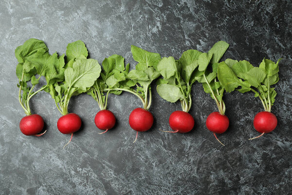 Fresh radish on black smokey background, space for text