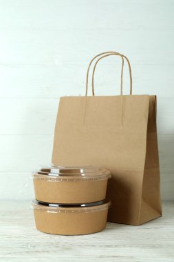 Kâğıt kaseler ve kağıt torba beyaz ahşap masada.